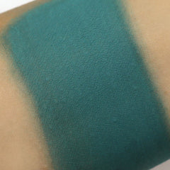 Teal eyeshadow swatch on skin, showing color and texture of product application