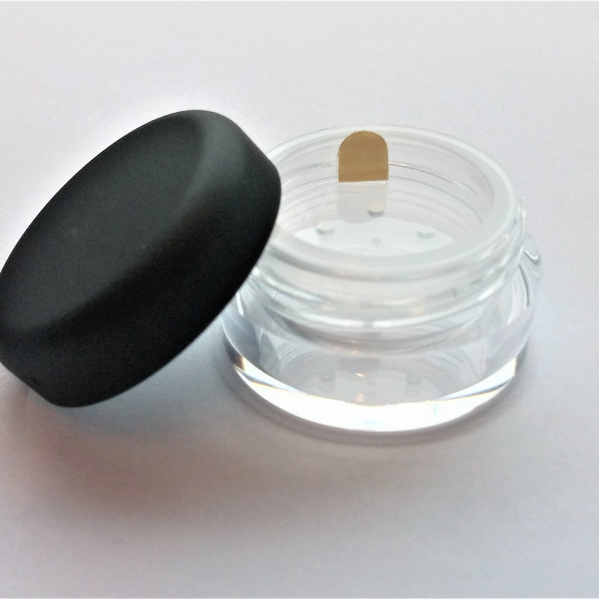 Close-up of Bella Lugosi mineral eye shadow pot showing deep burgundy powder with metallic shimmer finish