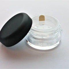 Close-up of Bella Lugosi mineral eye shadow pot showing deep burgundy powder with metallic shimmer finish