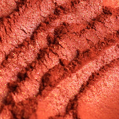 Eye shadow, coral pink duochrome powder, textured surface with glitter flecks