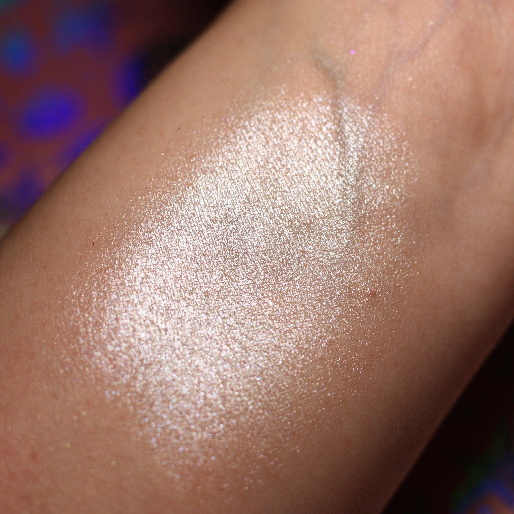 Close-up of fingertips applying shimmering taupe Leia Eye Shadow to eyelid with soft blending motion
