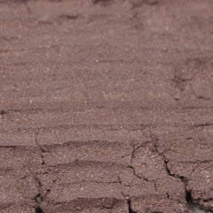 Hand applying shimmering cool mauve loose powder eyeshadow with a brush for a soft, blended look