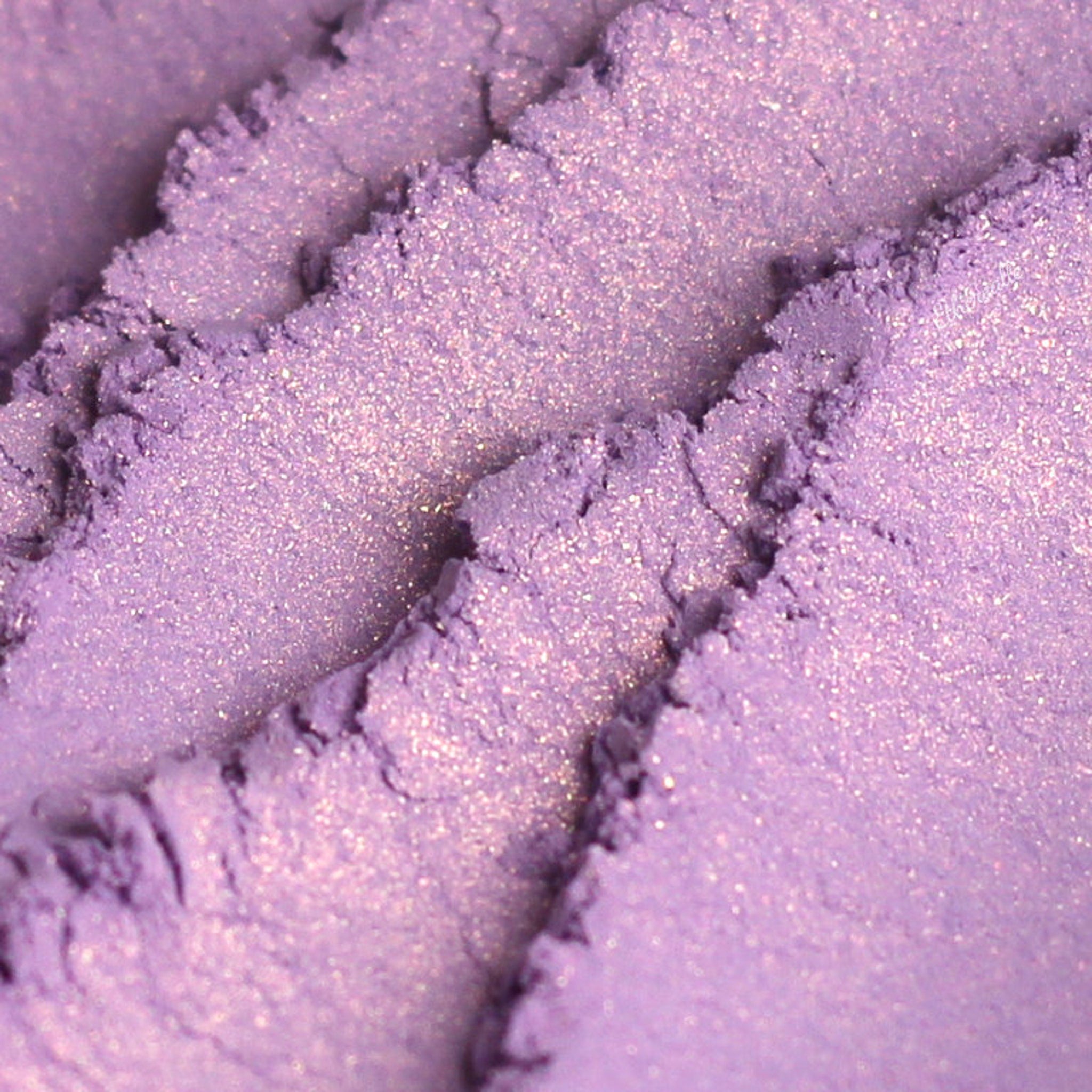 Purple eyeshadow powder with shimmer, close-up of textured material