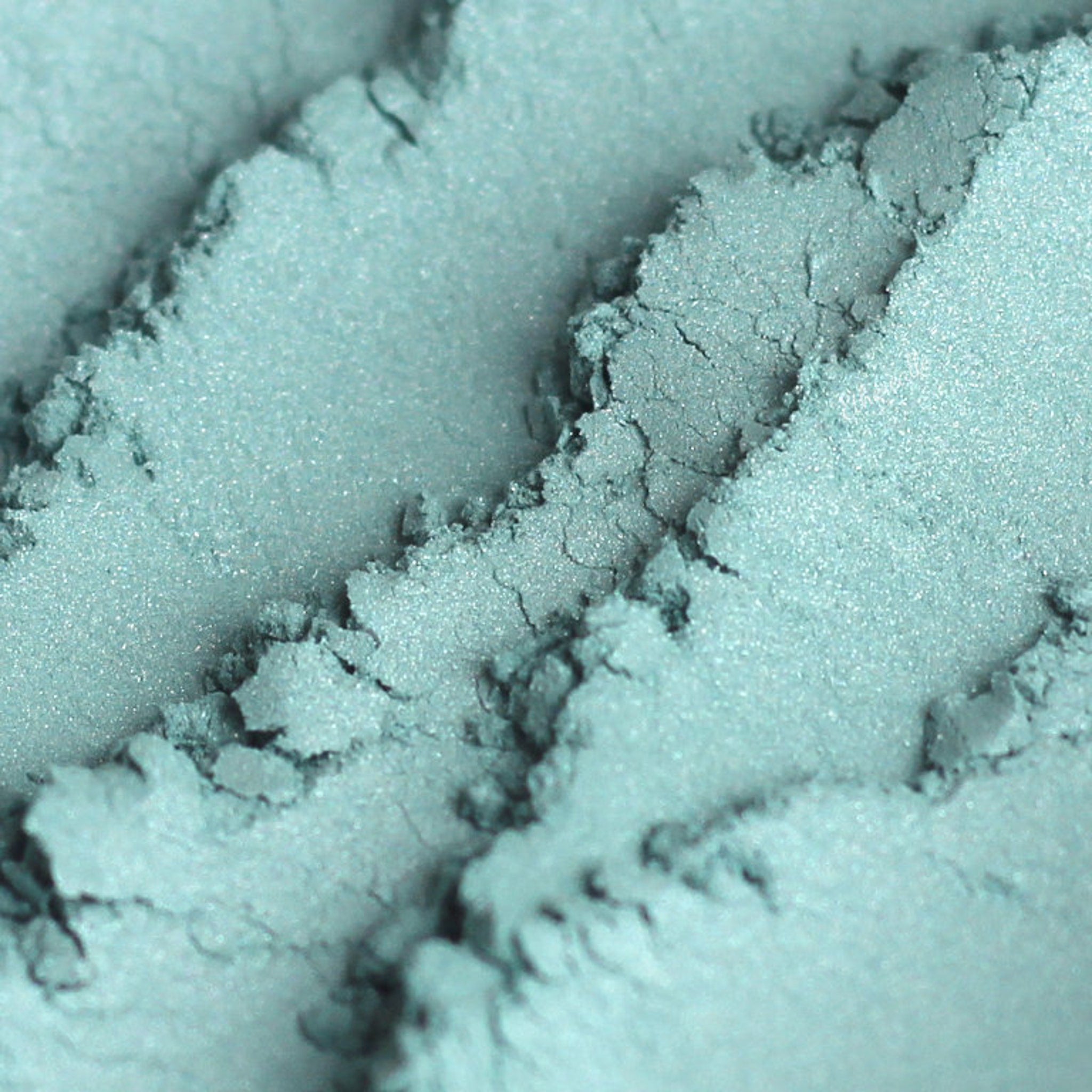 Frosty aqua blue mineral eyeshadow in shimmer finish, vegan and cruelty-free, shown in compact pan.