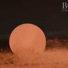 Close-up of matte pressed eyeshadow single pan in warm chic orange and rich brown tones