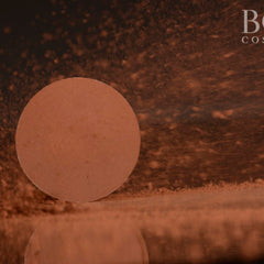 Side view of pressed red-brown matte eyeshadow single pan in 37mm compact showing texture and pigment depth
