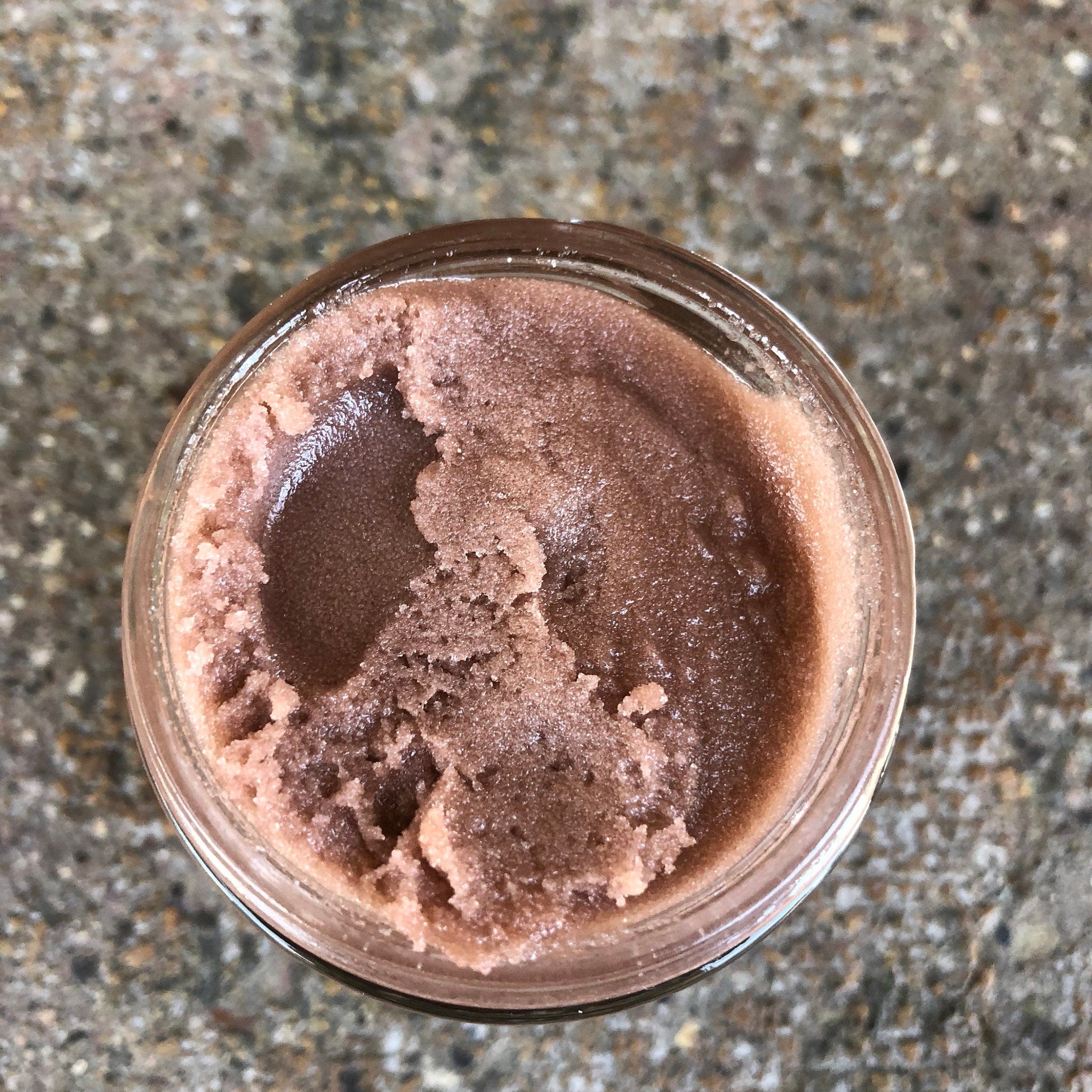 Body scrub in a glass jar, textured brown and pink, visible contents
