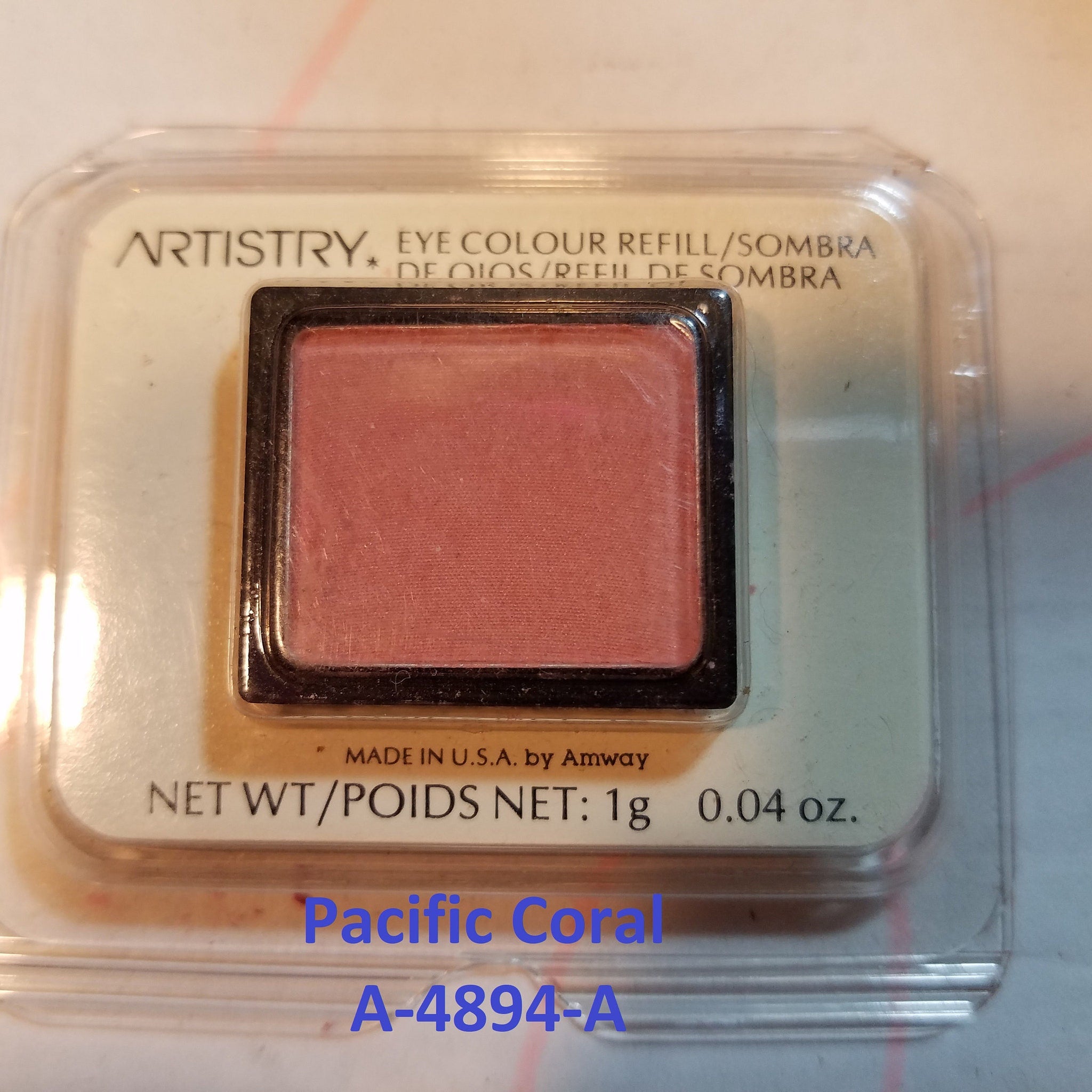 Side view of seven discontinued gray and pink powder eye shadows in sleek rectangular compacts with embossed logos