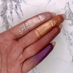 Eyeshadow swatches with metallic finish in pink, gold, red, and purple on fingers, Glitz brand