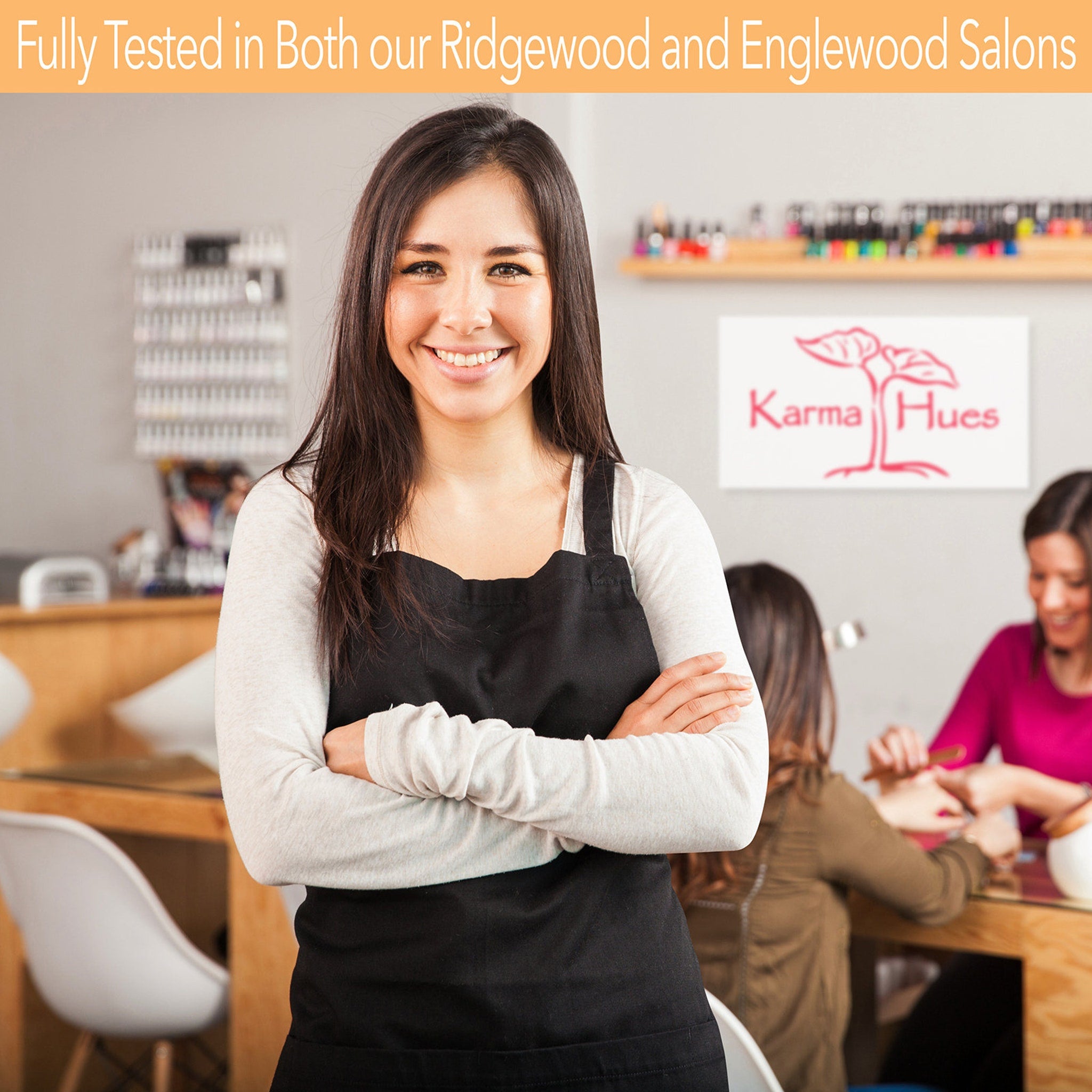 Salon worker in black apron, white long sleeve shirt, smiling in Karma Hues salon