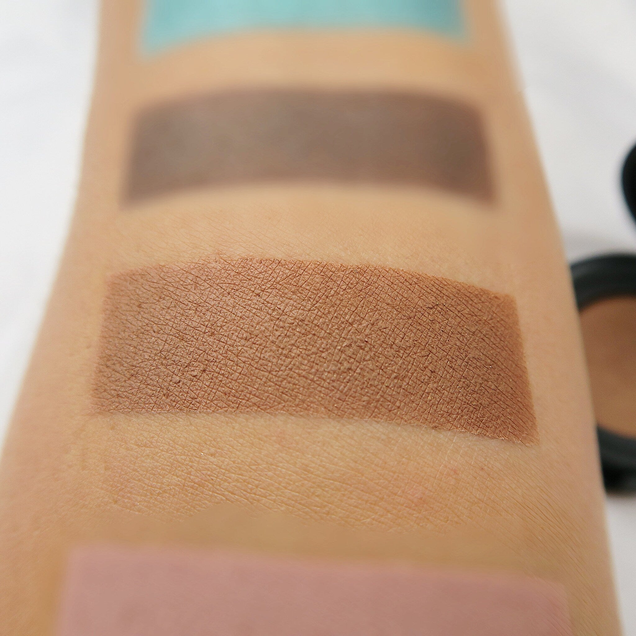 Hand applying vegan bamboo eyeshadow with a brush, showcasing smooth blendable texture on eyelid