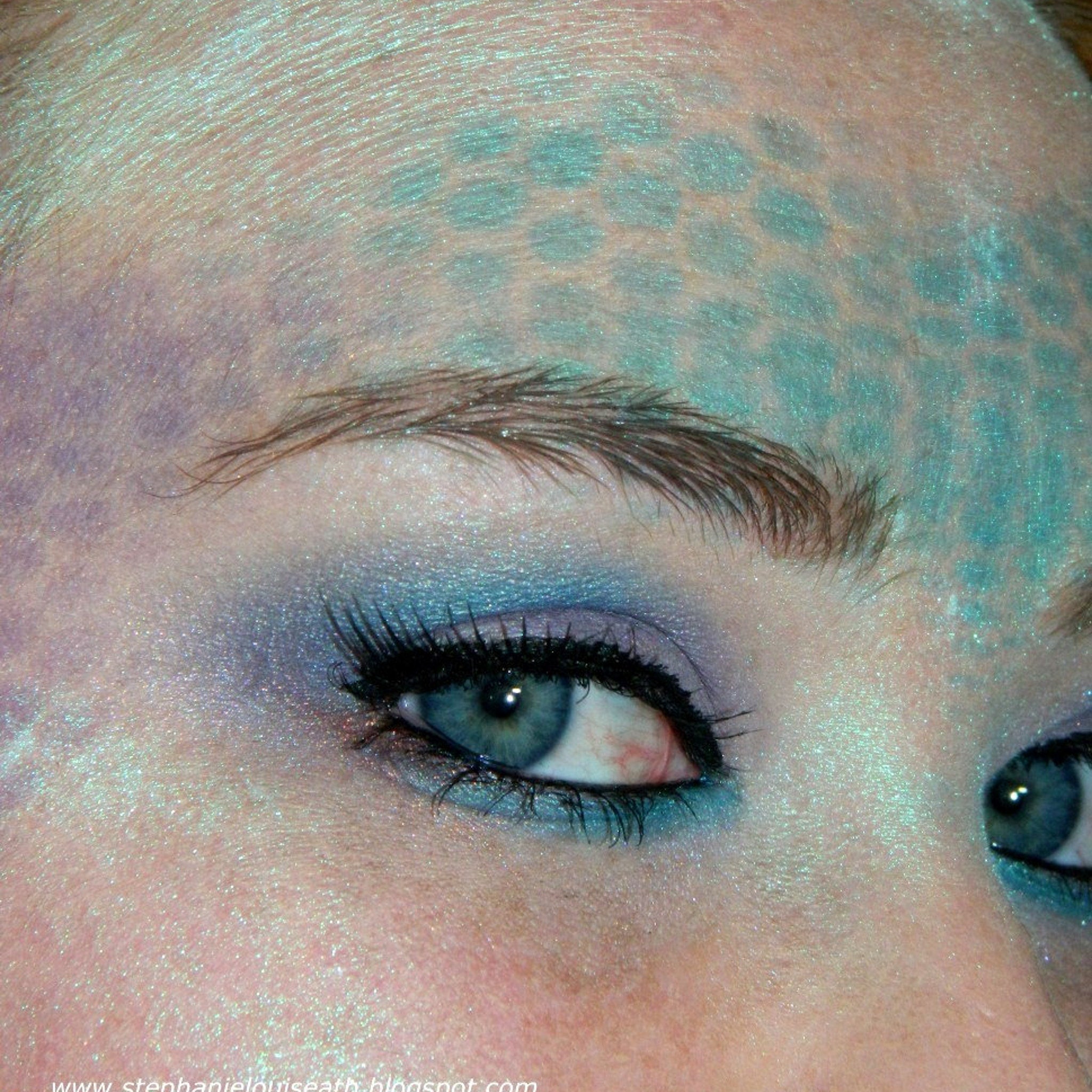 Sparkly mermaid eyeshadow palette open with vibrant teal and purple shades in sleek black compact
