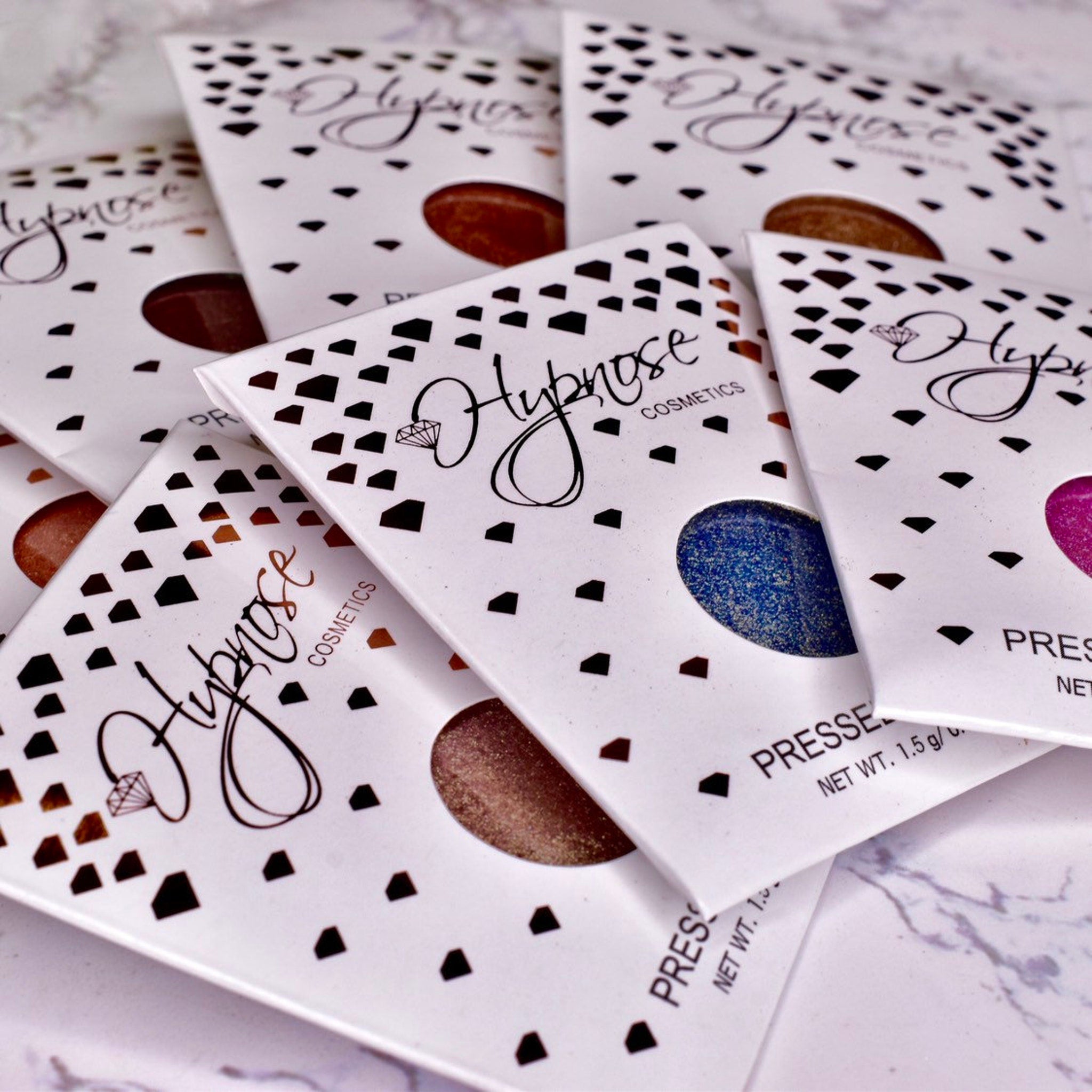 Pressed eyeshadow palettes with white packaging, black accents, and "Hypnose" text