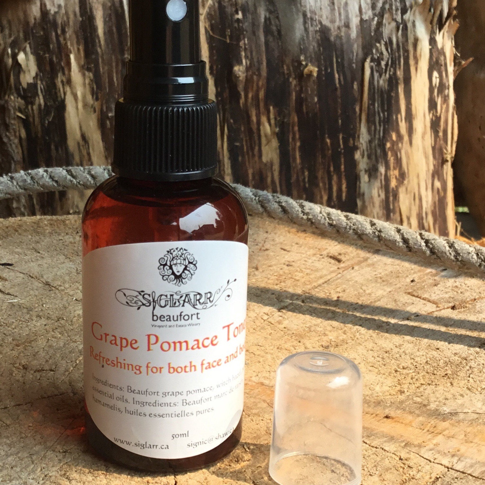 Toner bottle with red liquid, black cap, and white label, "SIGLARR" brand, on wood surface