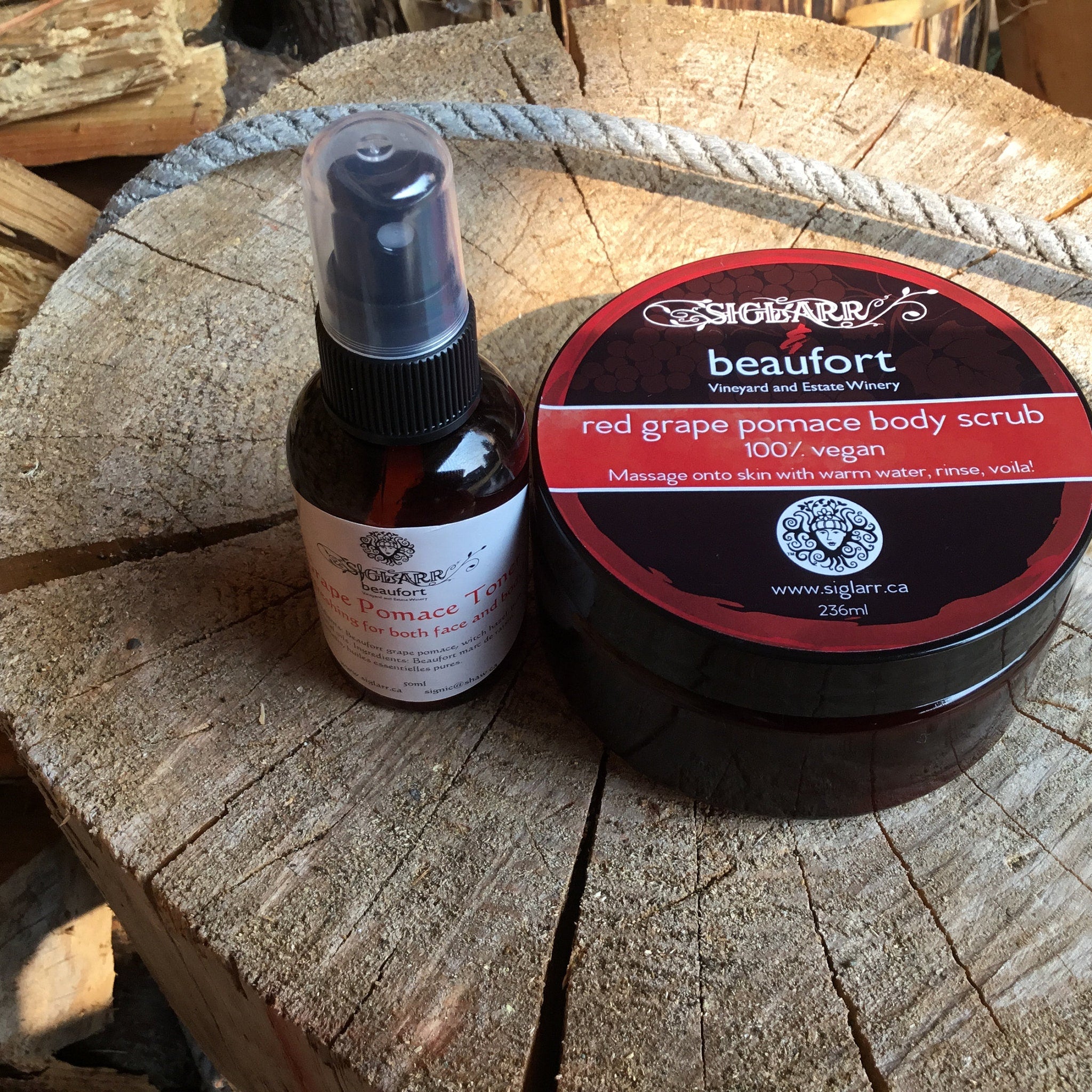 Body scrub and toner bottles on wood, SIGLARR brand with red and brown labels and black spray top