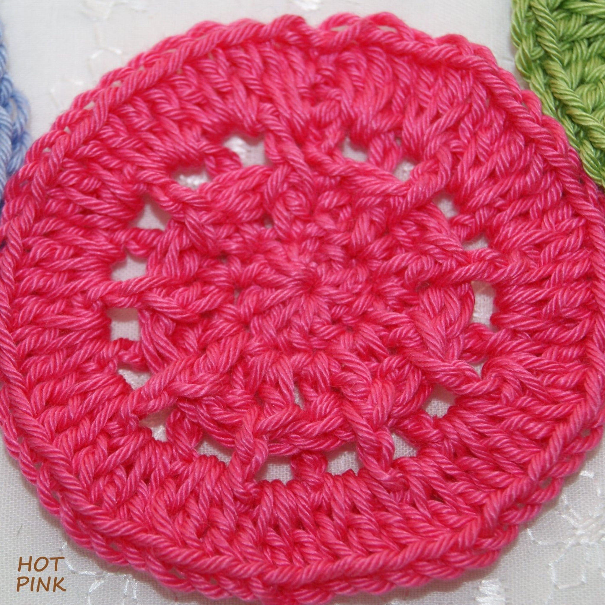 Crocheted circle in hot pink yarn with openwork design and visible texture