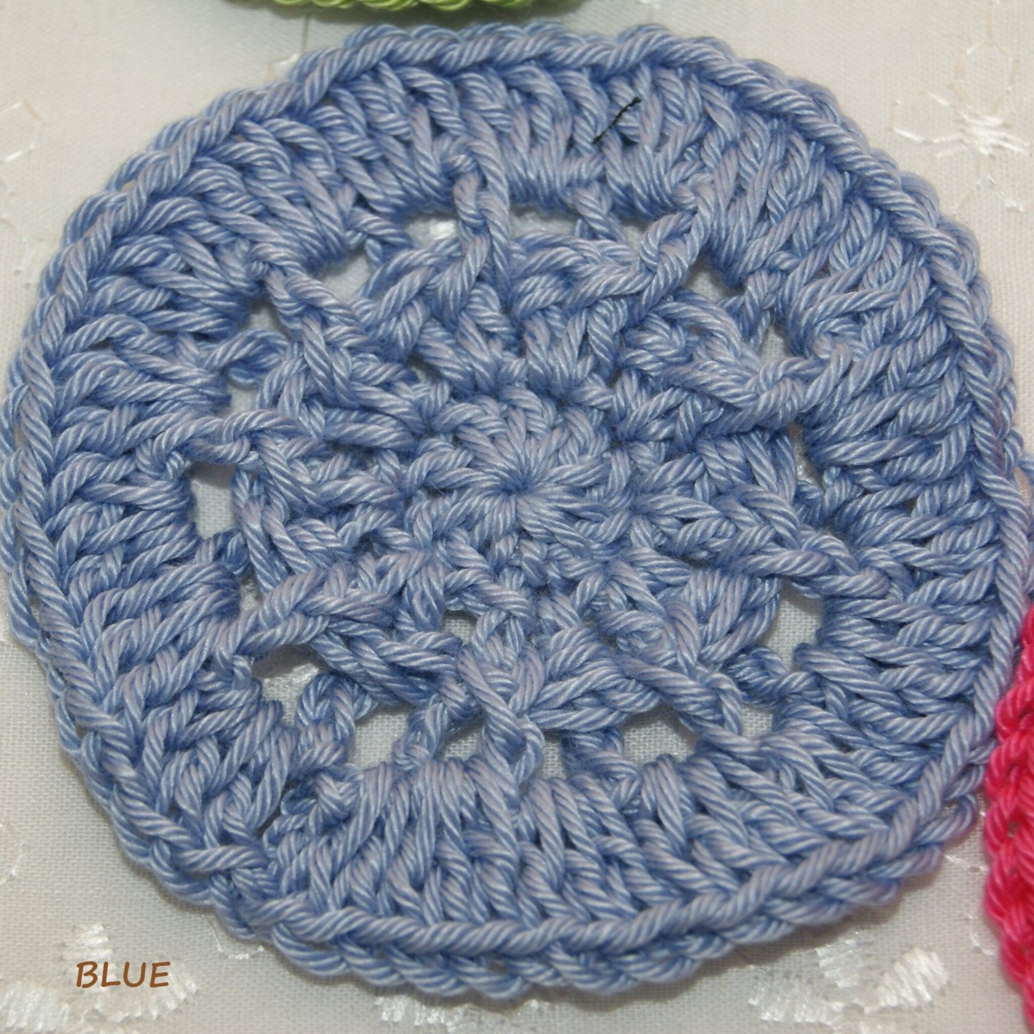 Crochet circle blue yarn openwork pattern BLUE text visible