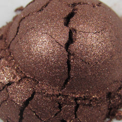Side view of dark copper brown loose powder eyeshadow with shimmer particles in a sleek glass jar