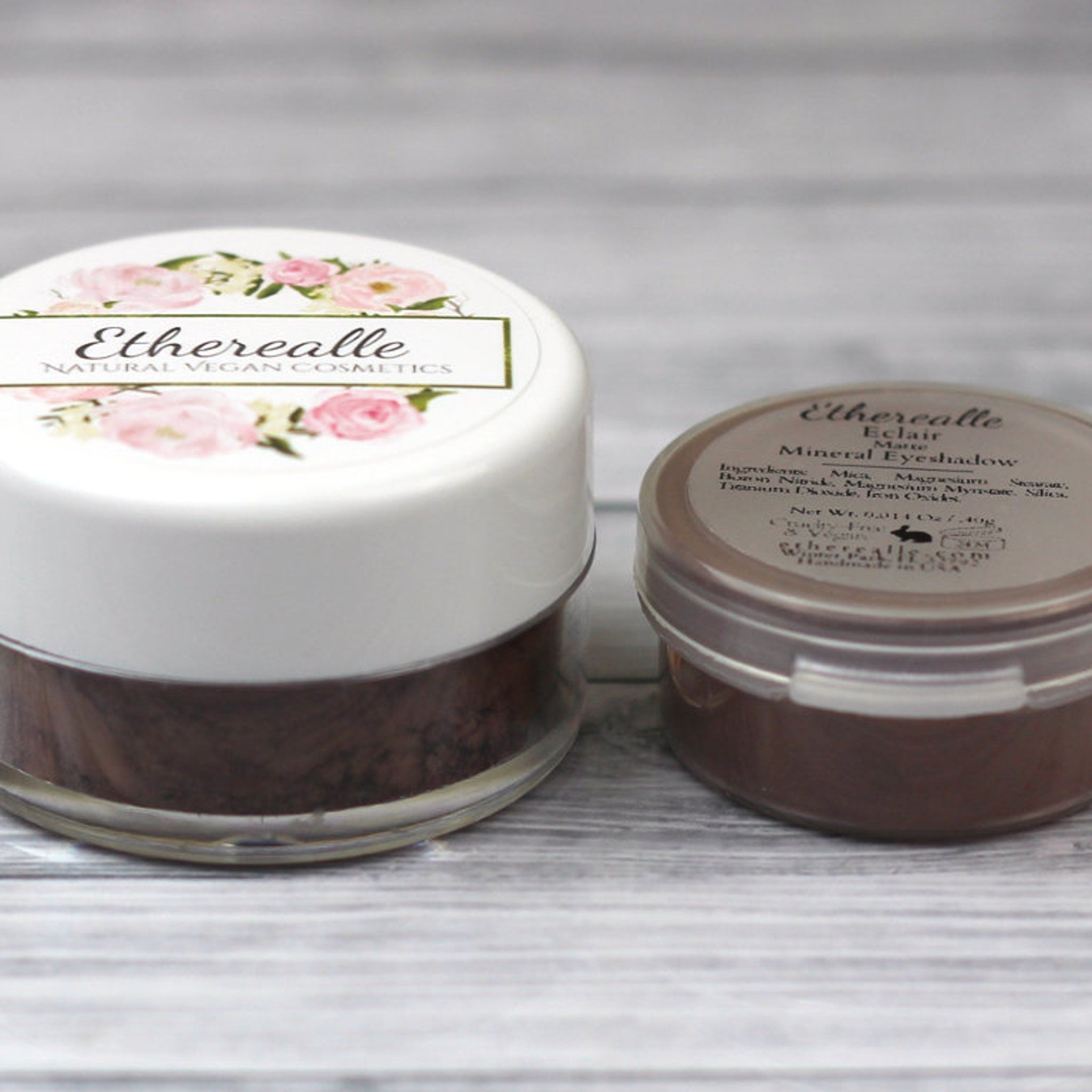 Eyeshadow pots with white and brown lids, floral label, and Etherealle brand text visible