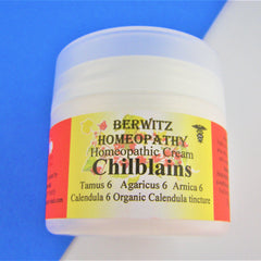 Homeopathic cream jar, white plastic container, yellow and red label with text, BERWITZ HOMEOPATHY branding visible