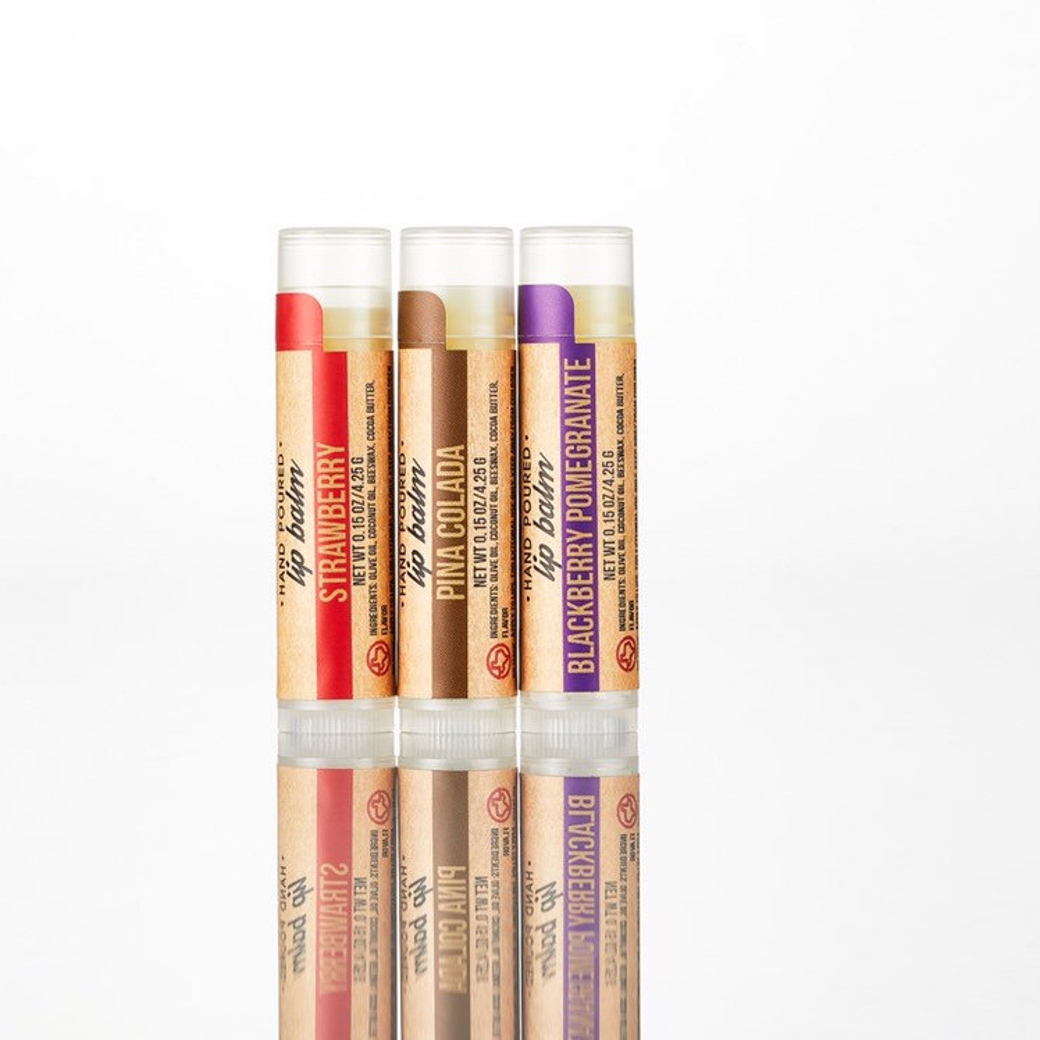 Lip balm tubes with red, brown, and purple labels, Sasha's brand, stacked for display