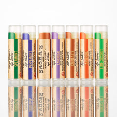 Lip balm tubes with green, purple, orange, and brown labels, Sasha's brand text visible