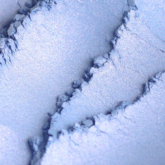Close-up of vegan mineral eyeshadow in shimmering blue with pink and turquoise flecks