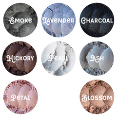 Side view of loose mineral eyeshadow in glass jar with metallic lid, showcasing powder texture and vegan label details