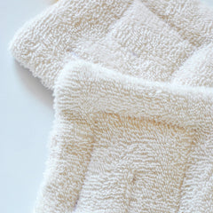 Close-up of organic cotton sponge wipe with textured surface for gentle facial cleansing