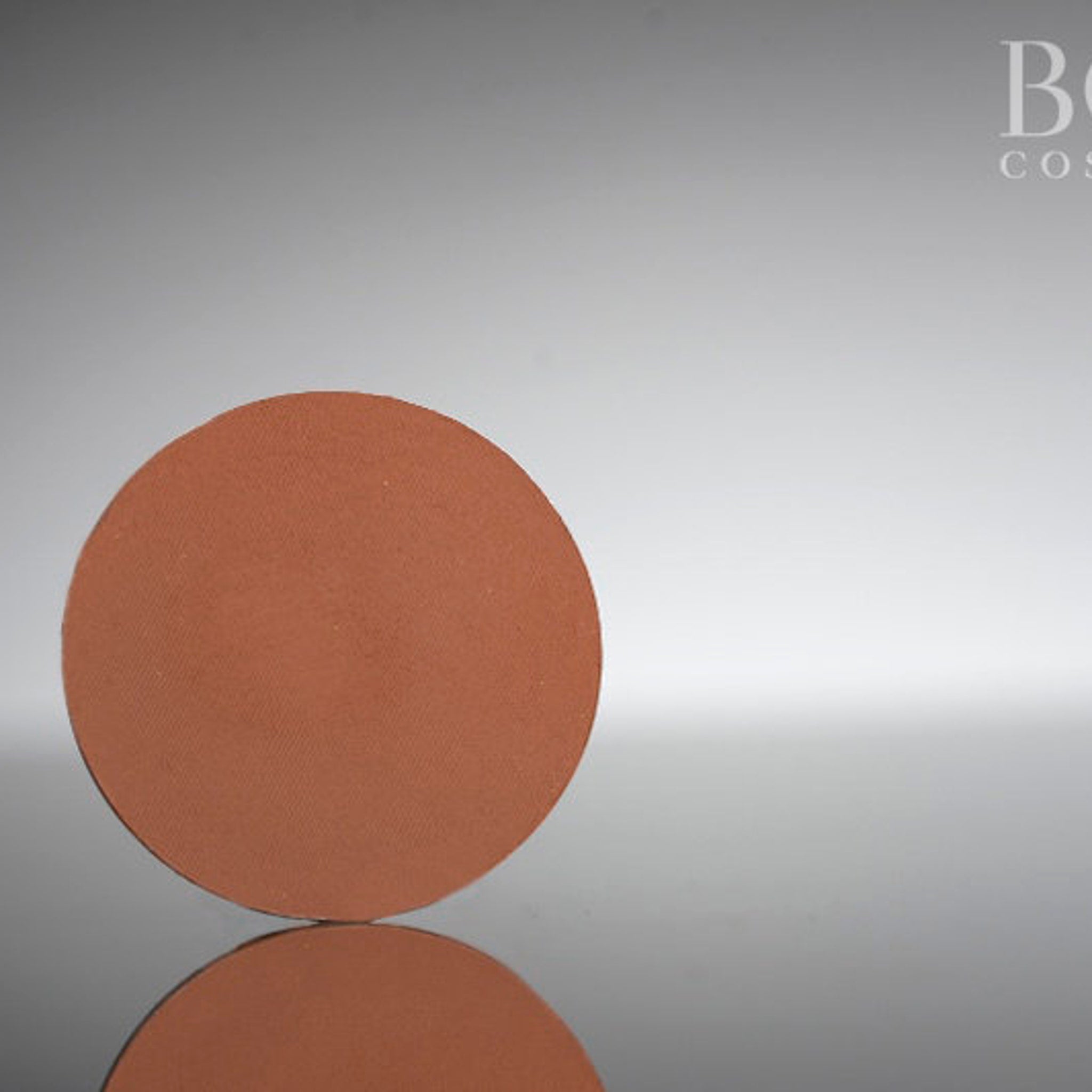 Single pressed eyeshadow pan in a rich matte red-brown shade with 37mm diameter