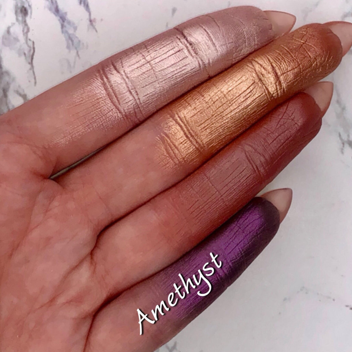 Close-up of amethyst duochrome foiled eyeshadow pan with metallic purple and pink shift, vegan mineral formula
