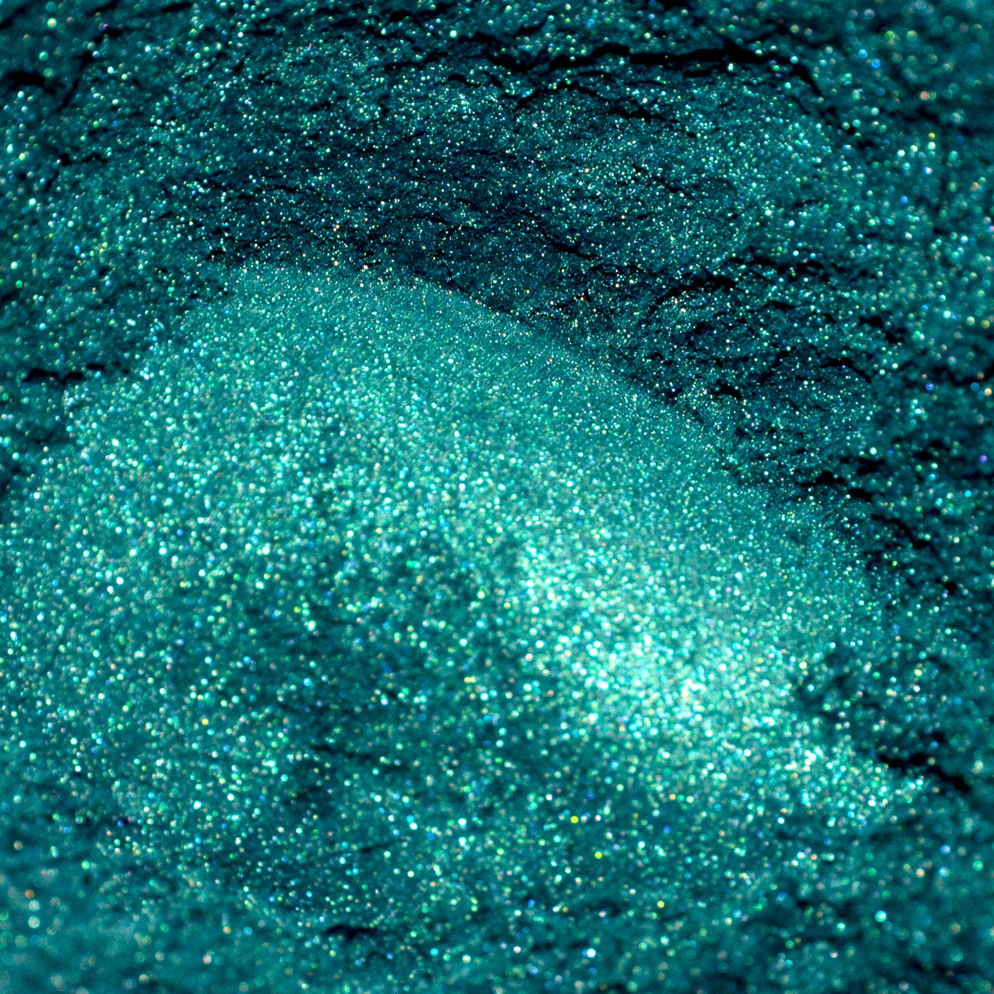 Teal glitter powder with sparkling texture and iridescent finish