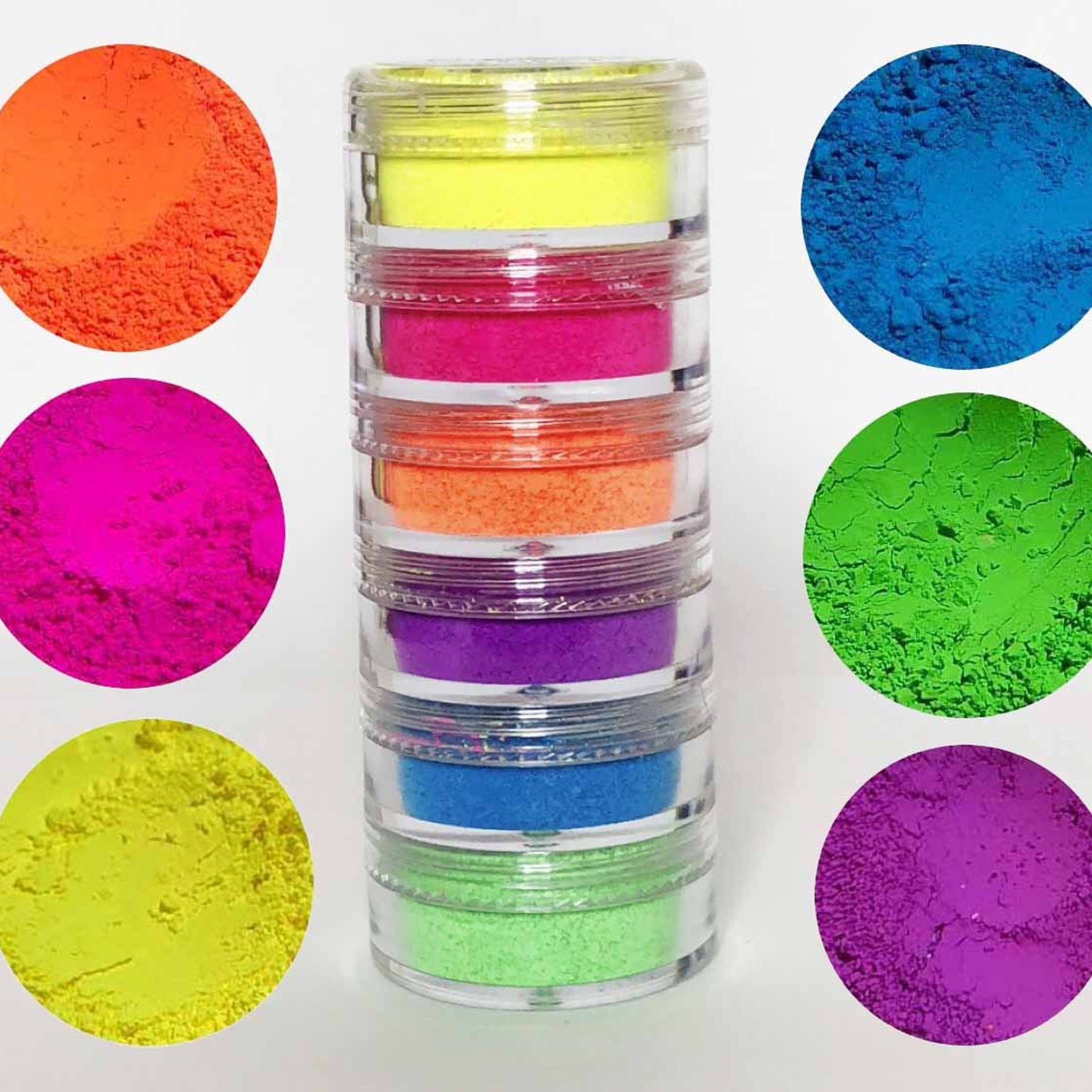 Neon pigment powders in various colors, stacked in clear jars, cosmetic use