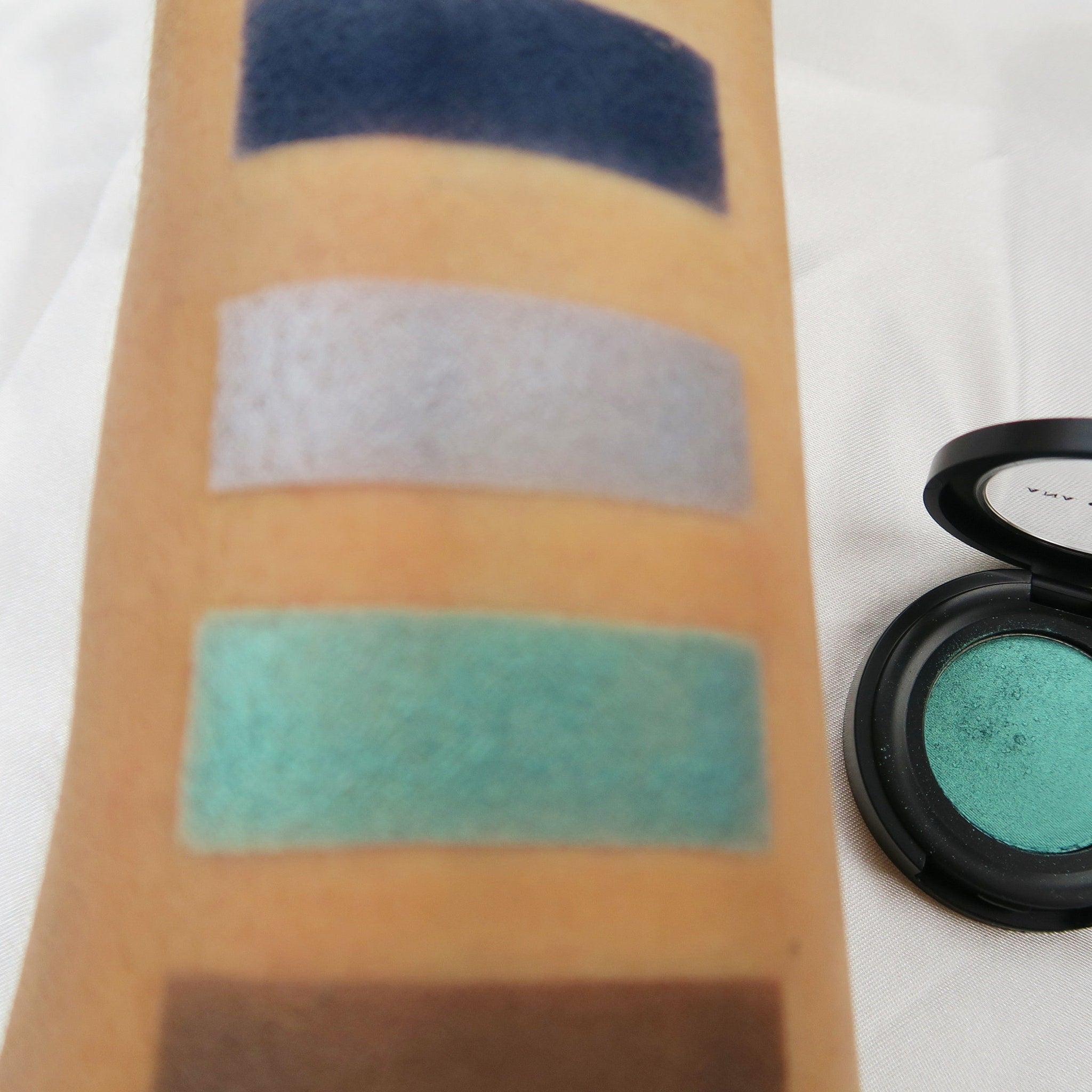 Open compact showing vibrant mermaid green eyeshadow with mirror and applicator