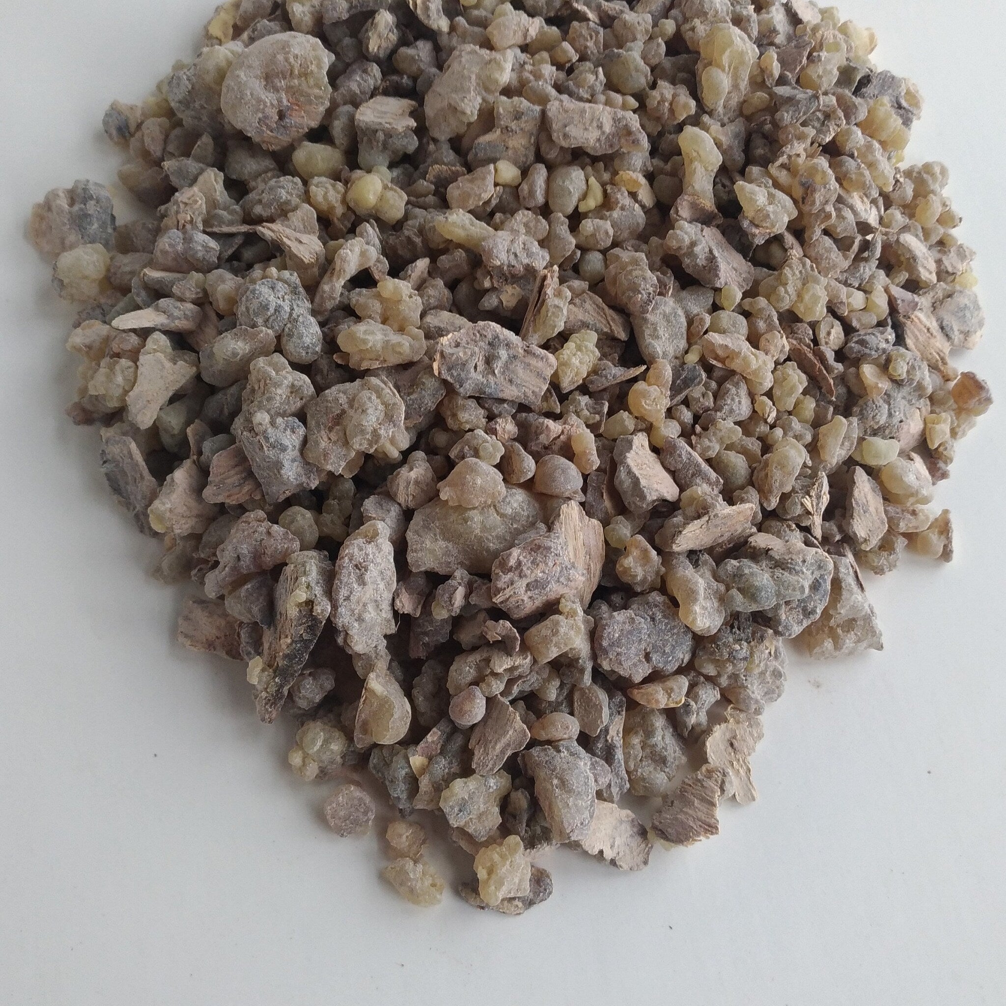 Incense resin pieces in beige, tan, and gray colors on white surface