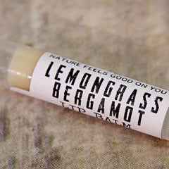 Lip balm tube with white label, black text, and light yellow balm visible