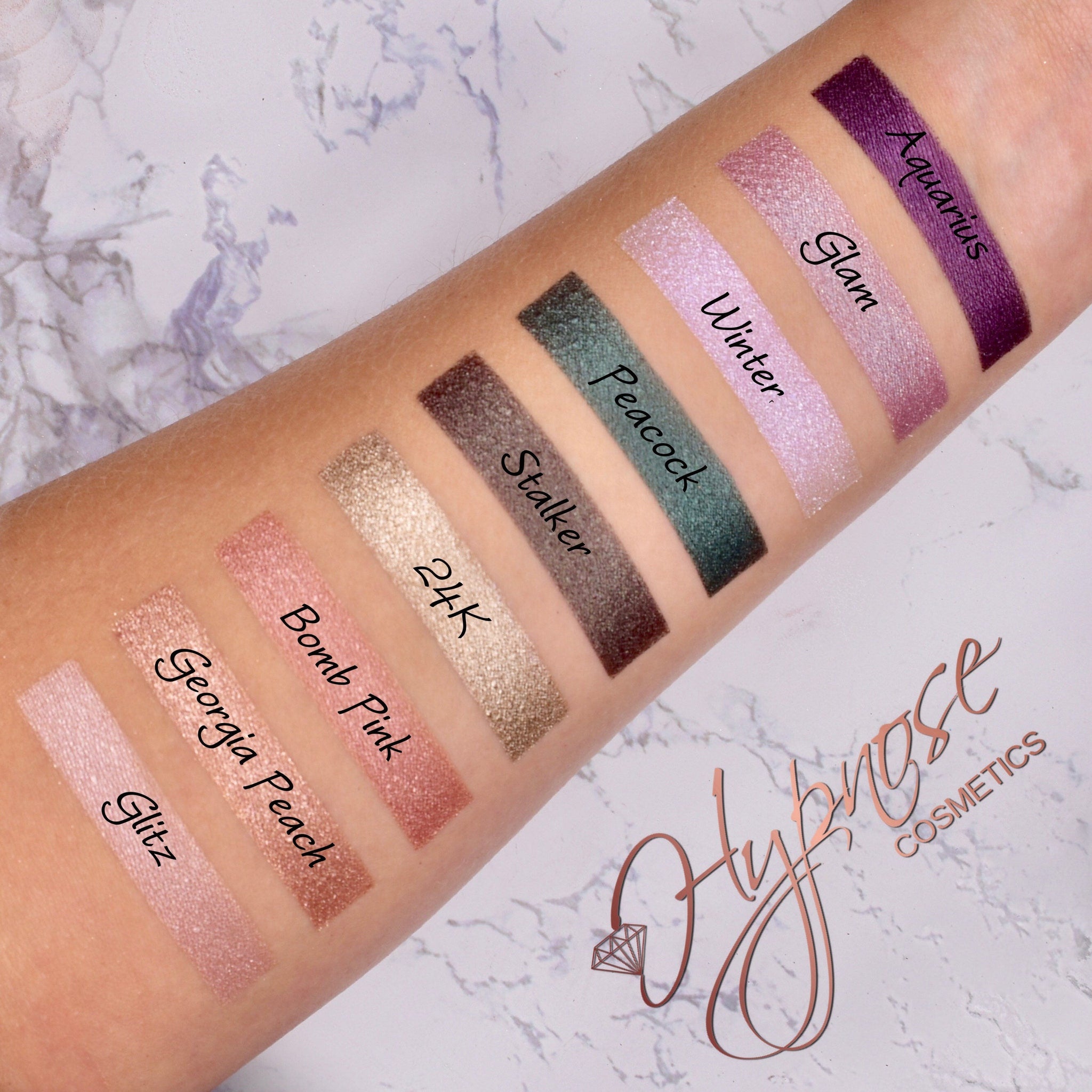 Eyeshadow swatches with various colors and Glitz brand name visible on arm