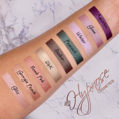 Eyeshadow swatches with various colors and Glitz brand name visible on arm