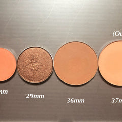 Eyeshadow palette with various shades of orange and brown, metallic and matte finishes, and different sizes