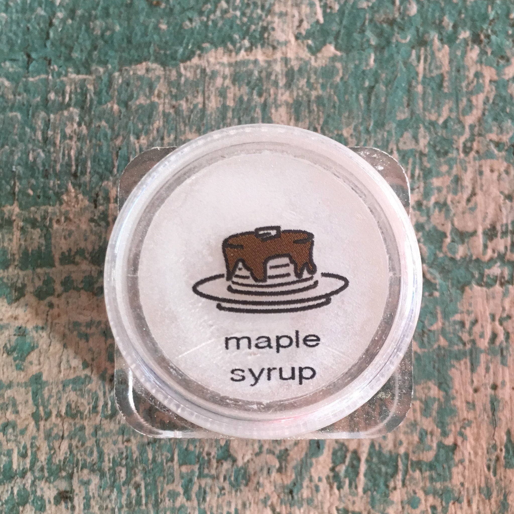 Eye shadow shimmer in clear plastic jar with maple syrup graphic on label