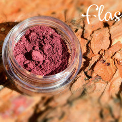 Small round plastic jar of pigmented mineral eye shadow in vibrant flash color with built-in sifter