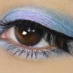 Close-up of vegan mineral eyeshadow in shifting blue-purple duochrome with sparkling metallic finish