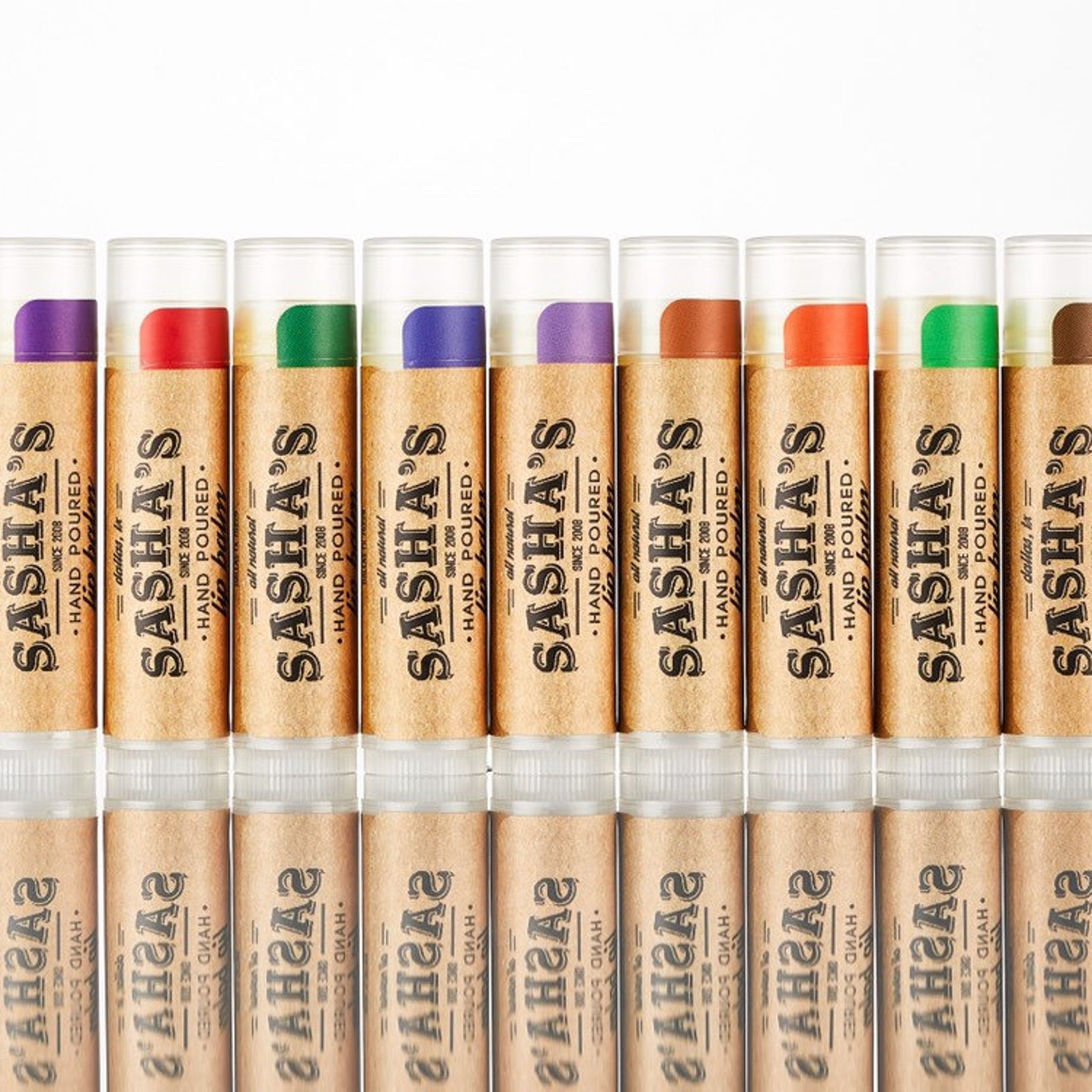Lip balm tubes with various colored tops and brown paper labels, Sasha's brand visible