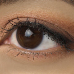Eyeshadow applied on eye, warm brown matte color, close-up view of eye with lashes