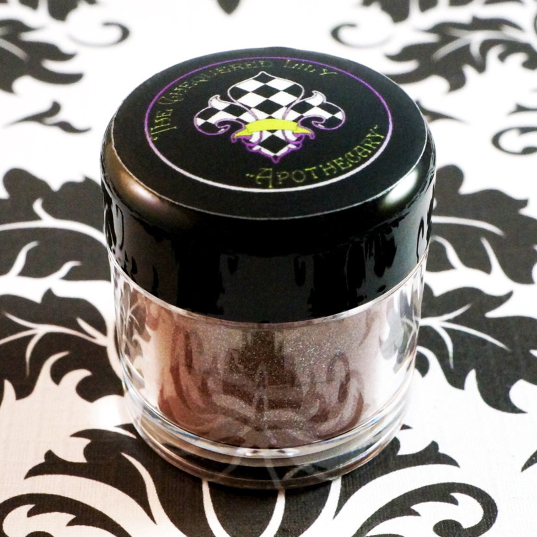 Close-up of duochrome eyeshadow pan shifting from green to brown with iridescent shimmer