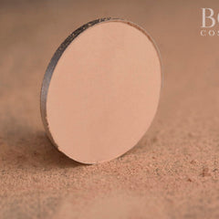 Side view of matte pink eyeshadow pan showing pressed powder texture and circular shape in compact
