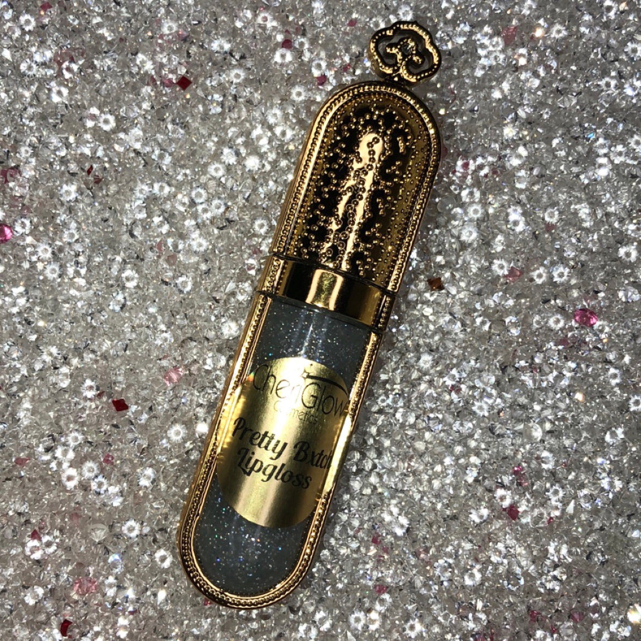 Lipgloss tube with gold casing, clear glittery liquid, and "Chen Glow Cosmetics" text