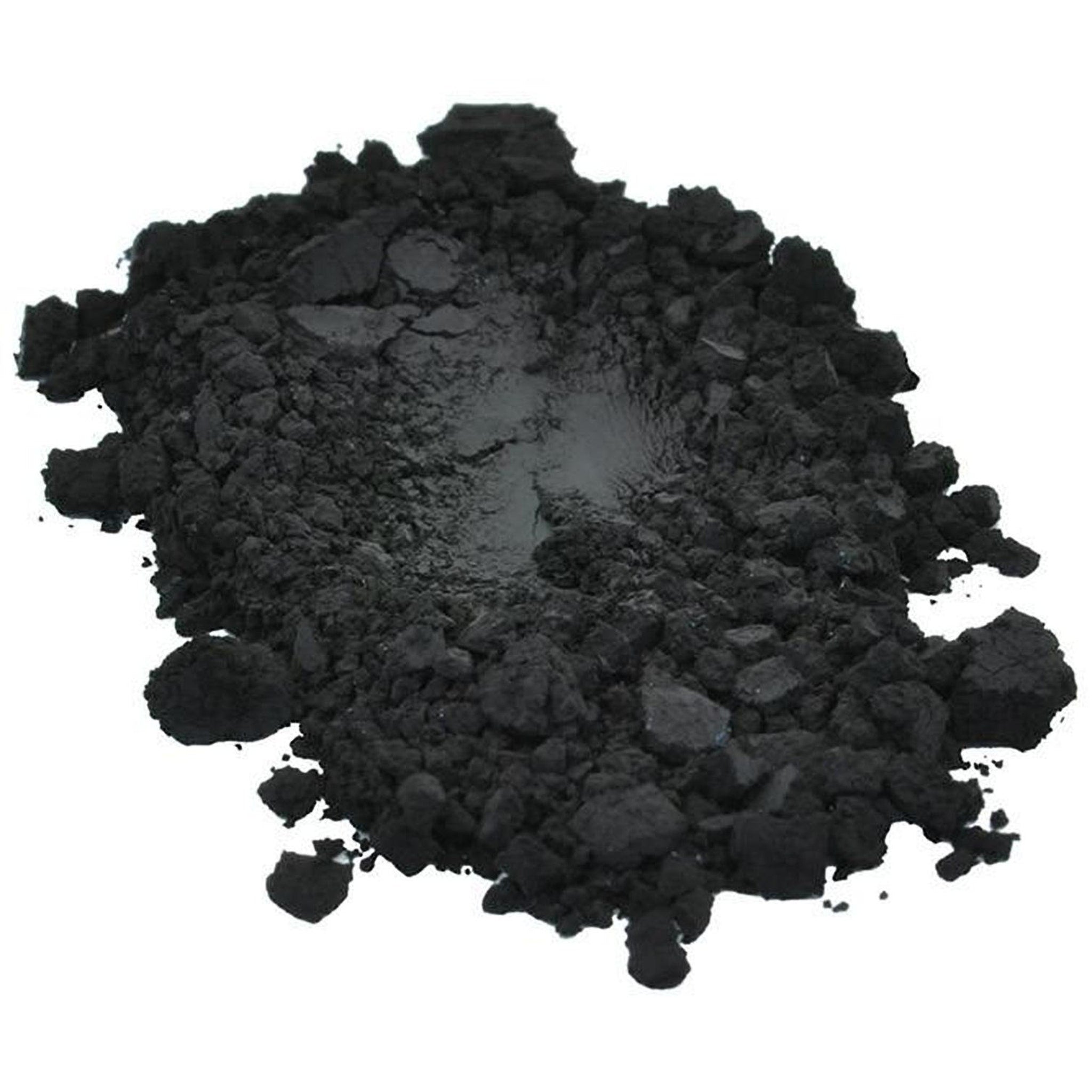 Hand applying black iron oxide pigment powder with a makeup brush onto eyelid for smoky eye look