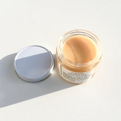 Facial cleanser jar with light peach balm, glass and silver lid, YUZANA label visible