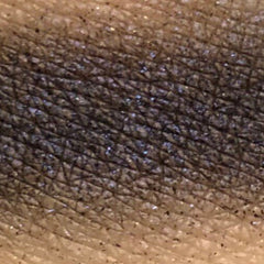 Close-up of fingertips applying pressed mineral eyeshadow in a circular motion to eyelid
